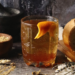 A honey old fashioned with an orange peel garnish.