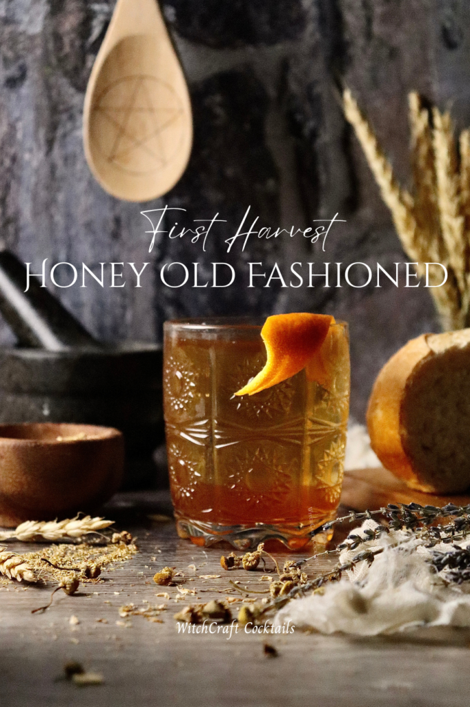 A harvest old fashioned with honey and an orange peel garnish.