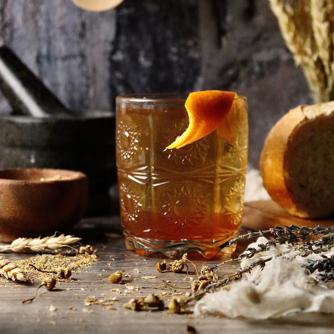 A honey old fashioned with orange peel garnish.