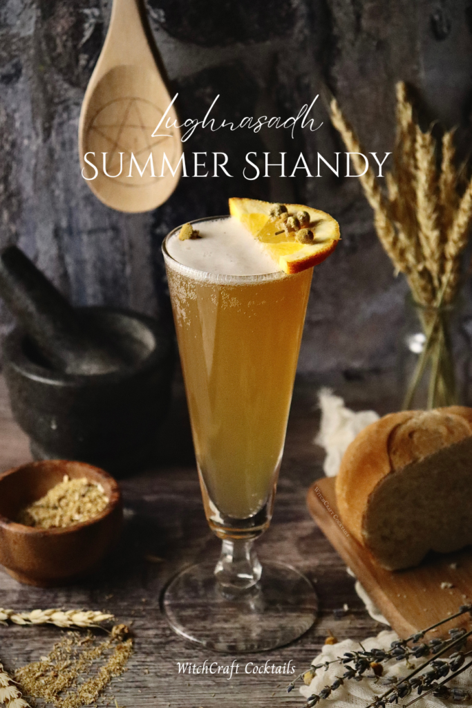 A golden lemon shandy with a half orange garnish