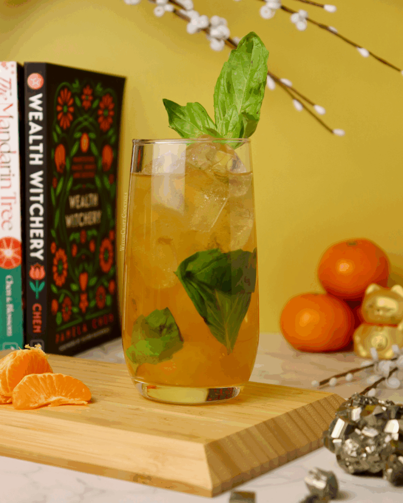 A vibrant citrus mocktail beverage featuring fresh basil, ice, and citrus in a tall glass, ideal for money manifestation and creative mocktail recipes.