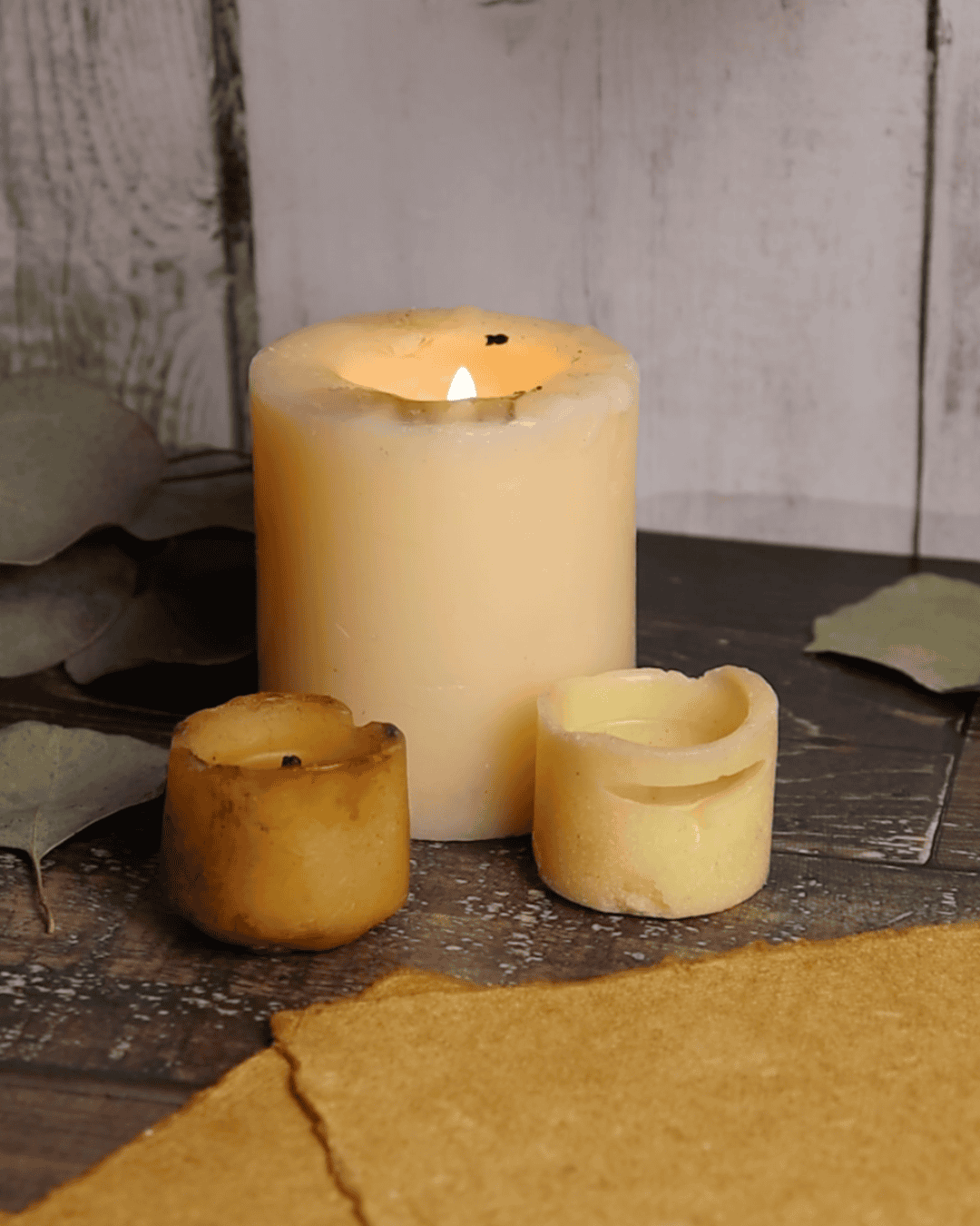3 cream candles, 1 lit.