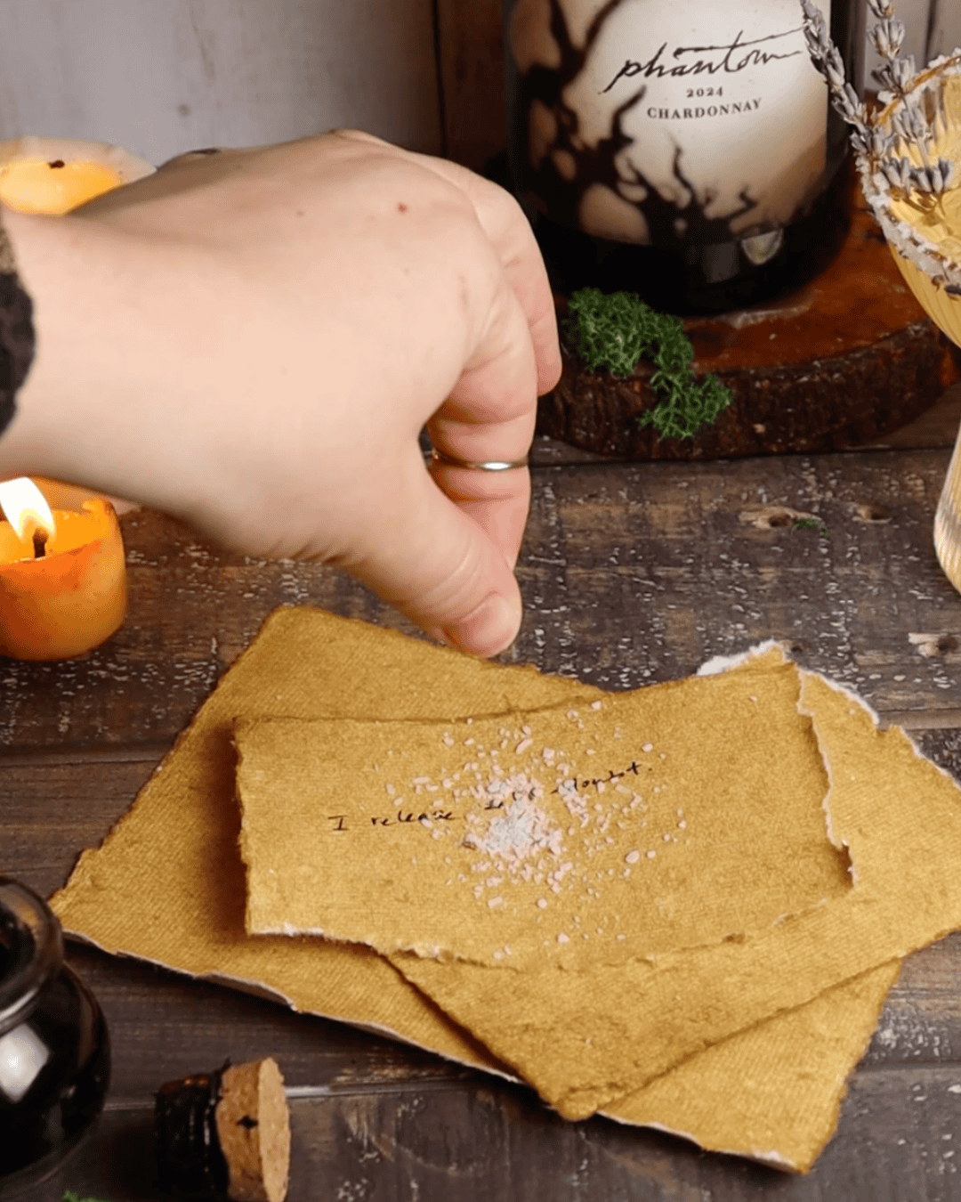 Sprinkling salt on aged paper slip for cleansing ritual.